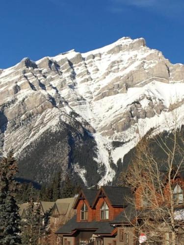 a house in front of a snow covered mountain at Hillside Bungalows in Banff