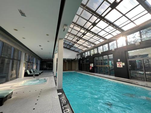 a large swimming pool in a building with a glass ceiling at 44th Floor, Panoramic Views, Bay Corridor Downtown Toronto Condo in Toronto