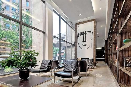 a lobby with chairs and a table in a building at 44th Floor, Panoramic Views, Bay Corridor Downtown Toronto Condo in Toronto
