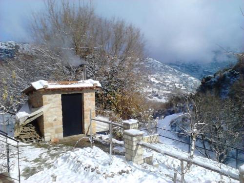 a small building with a door in the snow at Stone Mountainhouse near Kalavryta, North Peloponnese, Greece in Dhoumená