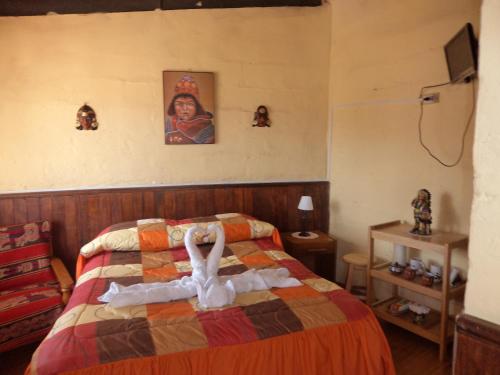 a bedroom with a bed with a swan on it at Samay Wasi Hostel in Cusco