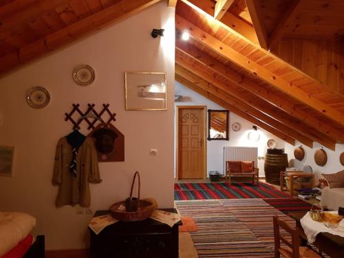 a living room with wooden ceilings and a room with at Stone Mountainhouse near Kalavryta, North Peloponnese, Greece in Dhoumená