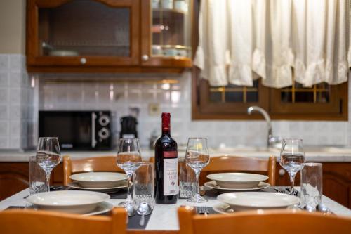 a table with a bottle of wine and glasses on it at Astria Apartment 1 in Kalabaka