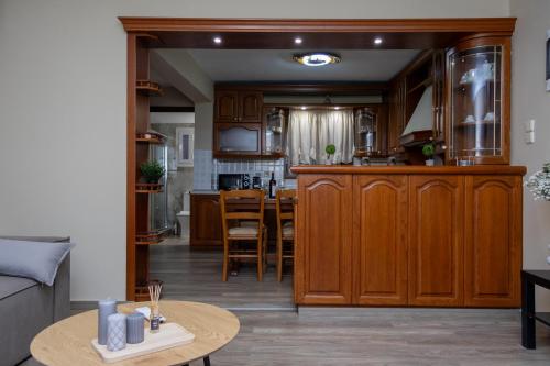 a kitchen with wooden cabinets and a table at Astria Apartment 1 in Kalabaka