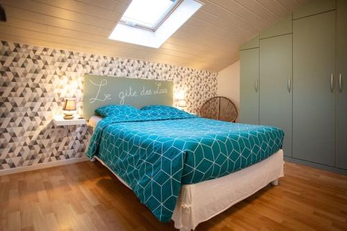 a bedroom with a bed with a blue comforter at Gîte des lacs in Meussia