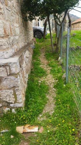 a stone wall with a car parked next to it at Stone Mountainhouse near Kalavryta, North Peloponnese, Greece in Dhoumená