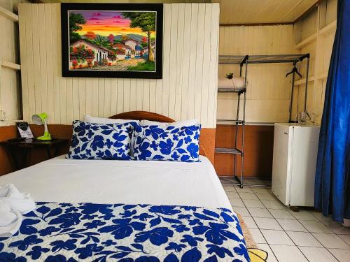a bedroom with a bed with a blue and white blanket at Tico Bed & Breakfast La Fortuna in Fortuna