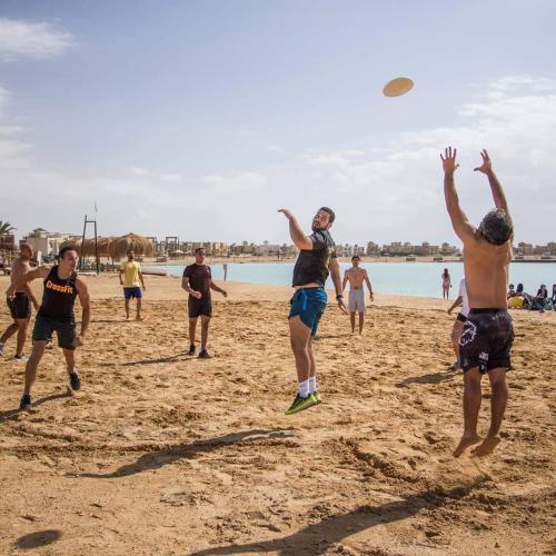 a group of people playing with a frisbee on the beach at Green Sudr Kitesurfing Hotel in Raʼs Matarma