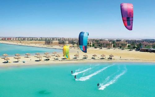 a group of people flying kites on a beach at Green Sudr Kitesurfing Hotel in Raʼs Matarma