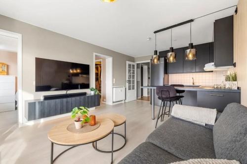 a living room and kitchen with a couch and a table at Demims Apartments Lillestrøm City Centre - Parking in Lillestrøm