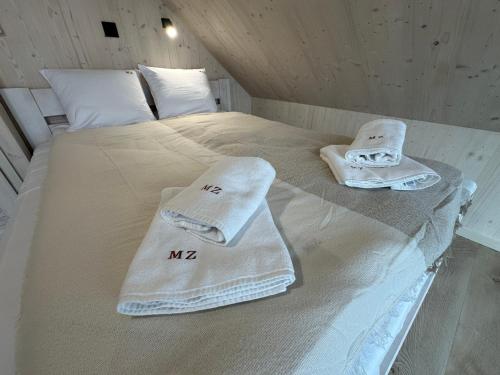 a bed with towels sitting on top of it at Mucharskie Zacisze in Zagórze