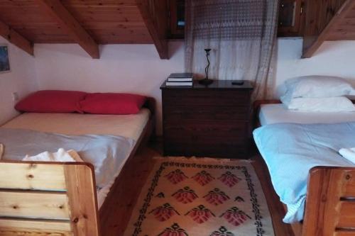 a bedroom with two twin beds and a dresser at Stone Mountainhouse near Kalavryta, North Peloponnese, Greece in Dhoumená