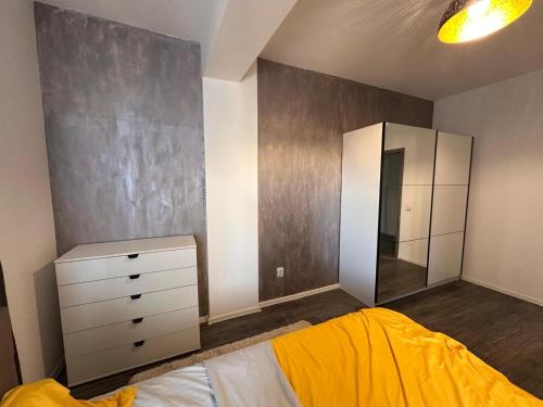 Un dormitorio con una cama, una cómoda y un espejo. en Apartament Central Craiova, en Craiova