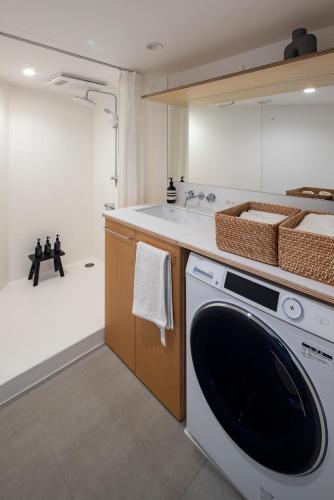 a kitchen with a washing machine and a sink at まえばしガレリアArt residence & Hotel in Maebashi
