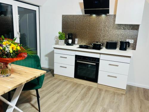 a kitchen with white cabinets and a table and a stove at Apartment 3 in Pulheim
