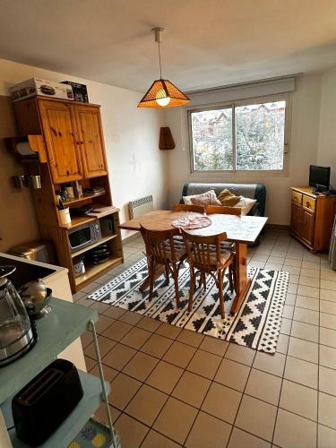 a kitchen and living room with a table and chairs at Appartement Centre Ville pied de piste Briançon in Briançon