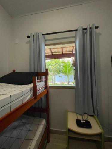 a bedroom with a bunk bed and a window at Sweet House Búzios in Búzios