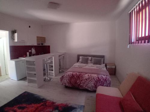 a bedroom with a bed and a desk and a desk and a chair at AlejaPark Inđija in Železnicka Stanica Inđija Selo