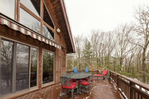 a patio with a table and chairs on a deck at The Cabin at Deep Hollow in Narrowsburg