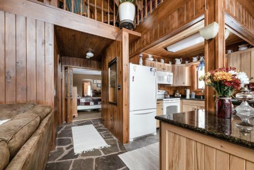 a kitchen and living room with a couch and a refrigerator at The Cabin at Deep Hollow in Narrowsburg