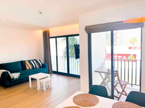 a living room with a blue couch and a balcony at BIA D'Olaf Apartments in Santa Maria