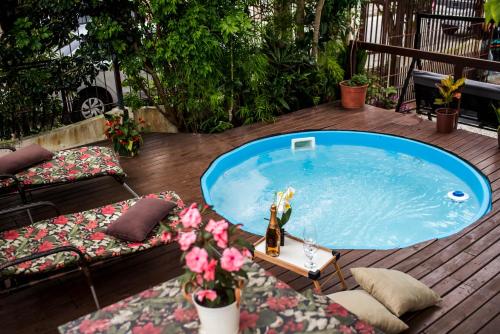 uma banheira de hidromassagem num deque com uma mesa e flores em Pousada Cancun em Florianópolis