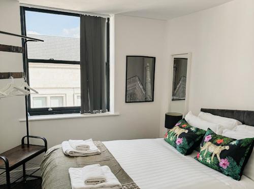 1 dormitorio con 1 cama con silla y ventana en Mathew Street 1 bed apt sleeps 6, en Liverpool
