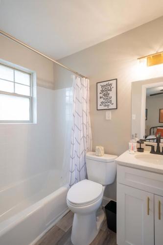 a white bathroom with a toilet and a sink at OV Mosaic - Float Suite in North Camellia Acres