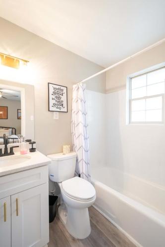 a white bathroom with a toilet and a sink at OV Mosaic - Bloom Suite in North Camellia Acres