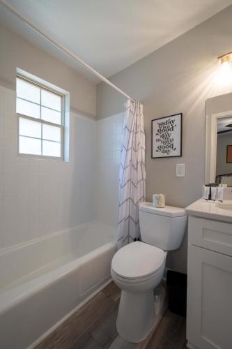 a bathroom with a toilet and a sink and a tub at OV Mosaic - Coconut Suite in North Camellia Acres