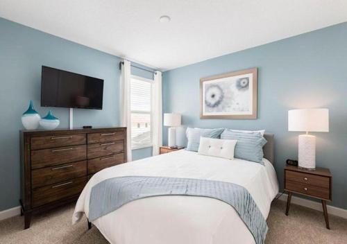 a bedroom with a large bed and a flat screen tv at Stunning Home wPrivate Pool, minutes from Disney in Davenport