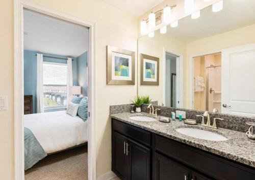 a bathroom with two sinks and a bedroom with a bed at Stunning Home wPrivate Pool, minutes from Disney in Davenport