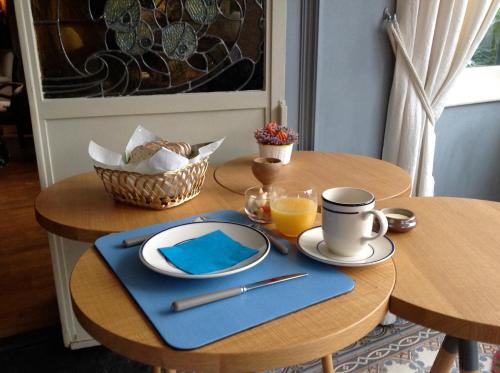 einen Tisch mit einem Teller und einer Tasse Orangensaft in der Unterkunft B&B La demeure du Papillon in Mouscron