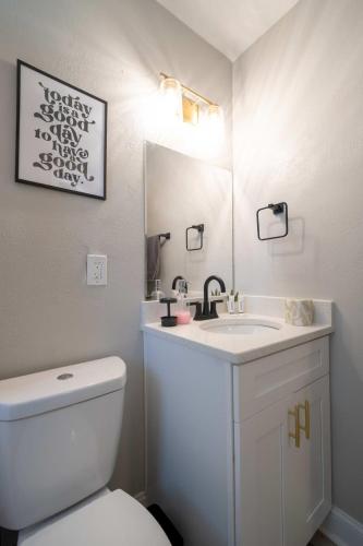 a bathroom with a white toilet and a sink at OV Mosaic - Rain Suite in North Camellia Acres