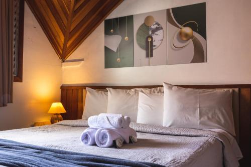 a bed with a stuffed animal on top of it at Pousada Araucária Suítes in Campos do Jordão