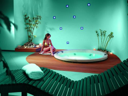 a woman sitting in a room with a tub at Hotel Mozart in Opatija