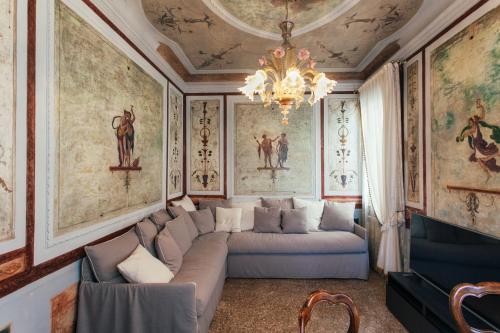 a living room with a couch and paintings on the walls at Residenza Dei Dogi in Venice