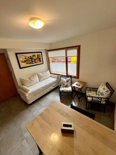 een woonkamer met een bank en een tafel bij Departamento M&L in San Martín de los Andes
