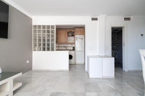 a white kitchen with white appliances and white cabinets at Frente al Mar y Paseo marítimo en el centro Marbella in Marbella