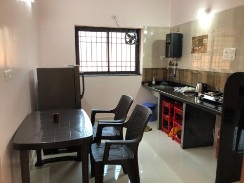 a small kitchen with a table and chairs in a room at Mahalaxmi Homestay II in Mapusa