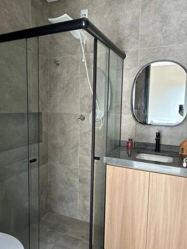 a bathroom with a shower with a sink and a mirror at Casa Villa Bali in Marechal Deodoro