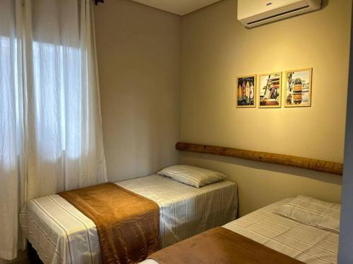 a room with two twin beds and a window at Casa Villa Bali in Marechal Deodoro
