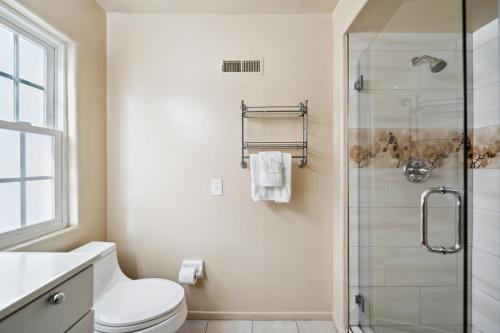 a bathroom with a toilet and a glass shower at Charming Beach Duplex Home in Corona del Mar in Newport Beach