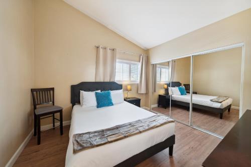 a bedroom with a bed and a chair and a mirror at Charming Beach Duplex Home in Corona del Mar in Newport Beach