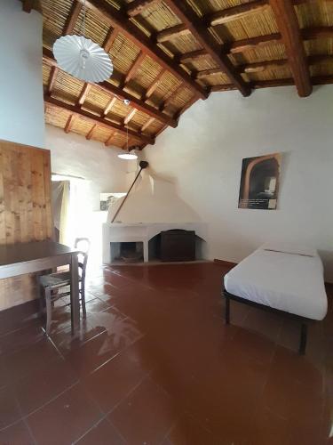 a bedroom with a bed and a desk and a table at Rebeccu Arte e Ospitalità - Ostello in Rebeccu