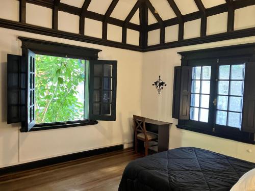a bedroom with two windows and a bed in it at Habitaciones privadas Casona Patrimonio Pocitos in Montevideo