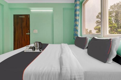 a large bed in a room with a window at Super Collection O The Kailash Hotel in Dehradun