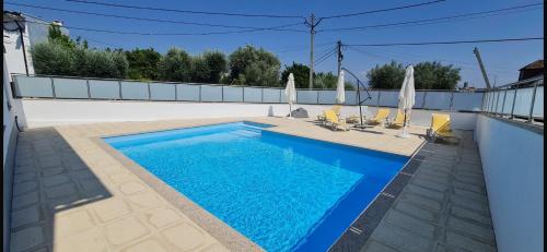 a swimming pool with chairs and umbrellas on a house at JP VILLAGE Hotel in Nelas