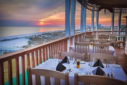 a restaurant with tables and chairs on a balcony with the beach at Destiny Beach Villas #20A in Destin