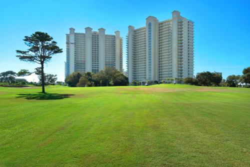 a green field with tall buildings in the background at Ariel Dunes II 101 in Destin
